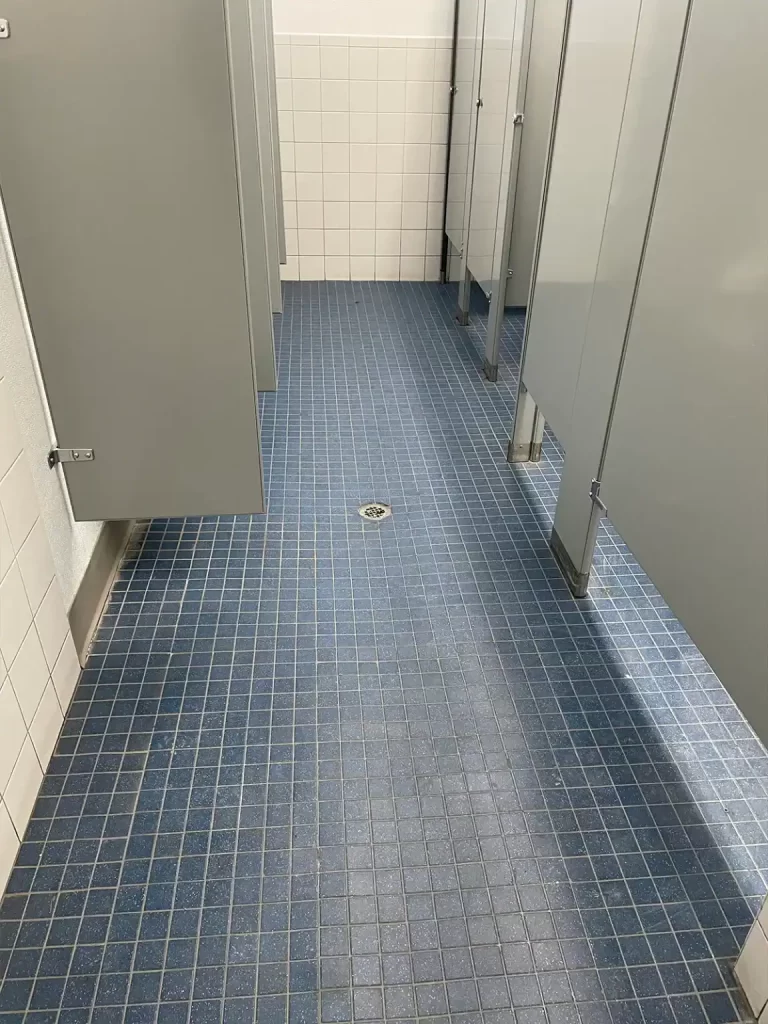 Clean bathroom tile floor after janitorial scrubbing and wash.