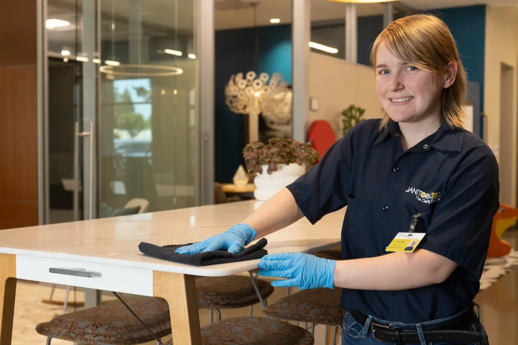 Professional cleaner wiping down an table in a commercial office